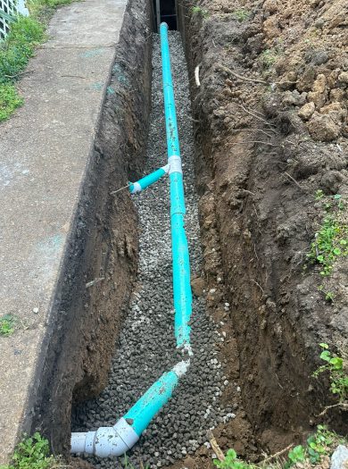 A blue pipe is laying in the dirt.